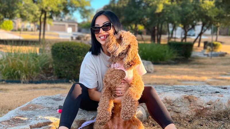 Gen Z woman with her dog, representing modern lifestyles and evolving priorities of today’s young parents.